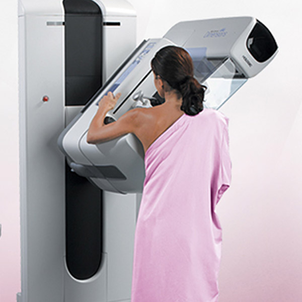 Woman in front of mammogram machine