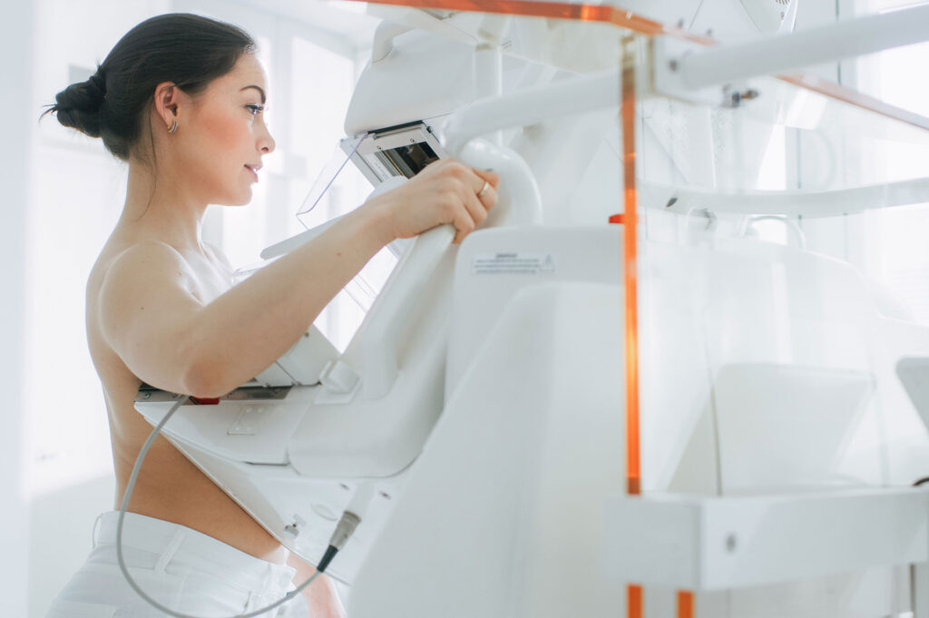 Woman in front of mammogram machine